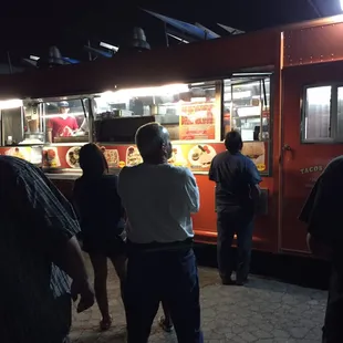 a group of people standing in front of a food truck