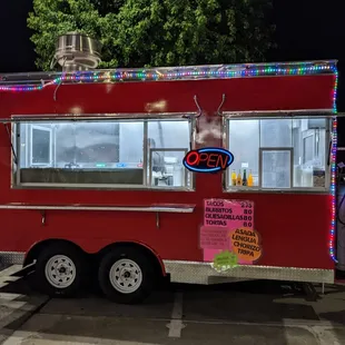 a red food truck parked in a parking lot