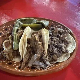 Two Al pastor tacos, one carne asada