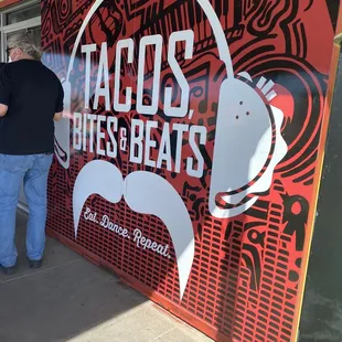 a man standing in front of a taco shop
