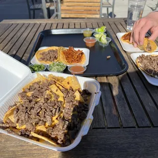 Nachos with carne asada, pastor and asada tacos, and asada vampiro.