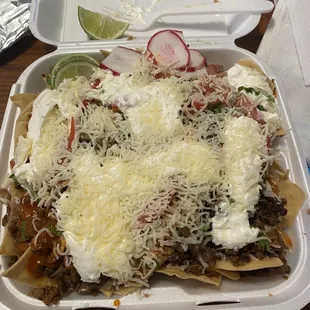 Nachos Supreme with asada. The lid barely closed on the container and it was heavy with food.