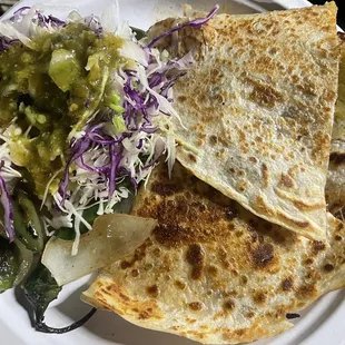 Birria quesadilla with complimentary salsa, peppers, and grilled onions.
