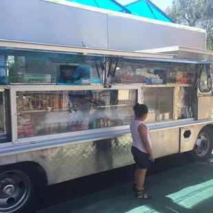 a woman standing in front of a food truck