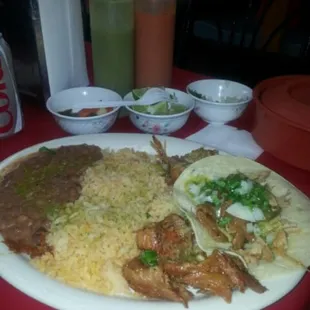 The 3 carnitas tacos with rice and beans. The red and green salsas...