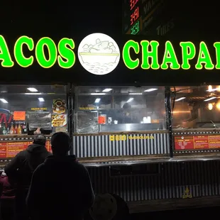 people standing in front of a taco stand