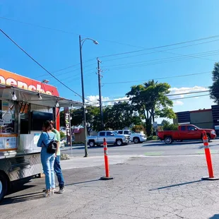 a woman standing in front of a taco truck