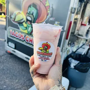 a hand holding a drink