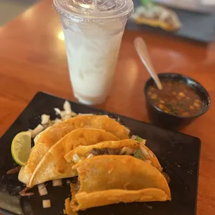 Birria taco, quesabirria and horchate. Asada taco im the background.