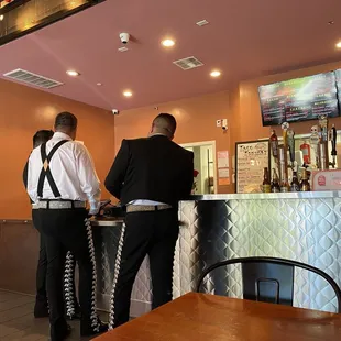 two men standing at a bar