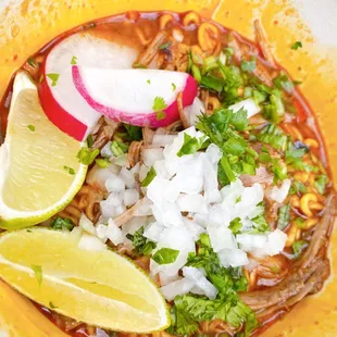 Ramen Birria Soup with lime, cilantro, onions, and radish