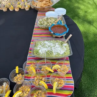 Cocktail hour for a wedding.  Couple chose to have chips, salsa, cabbage salsa, guacamole and elote cups