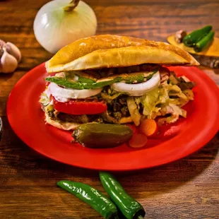 Torta - Trompo, bistec, barbacoa, shredded beef, or ham, with refriend beans, Mexican sour cream, lettuce, tomatoes, onions, &amp; avocado