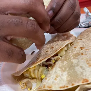 a person putting toppings on a tortilla