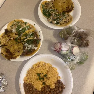 Side of Rice and Beans, asada &amp; chicken tacos, chicken mulitas. Limes, radishes, cucumbers, and red/green/guacamole salsas.