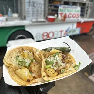 a hand holding a taco
