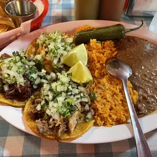 Three taco plate with rice and beans.