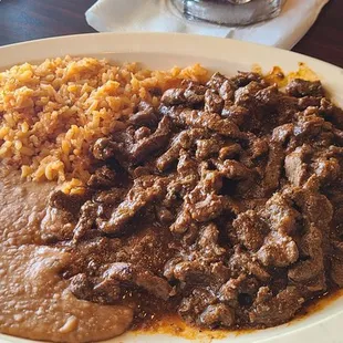 Chili Colorado served with rice and beans.