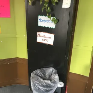 a trash can and a sign on a door