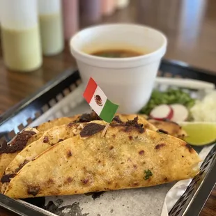 Tacos de birria de res con su consomé.