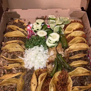 Asada (bottom right corner), Pastor (red meat) and chicken fajita (bottom left corner). Lots of toppings in the middle!