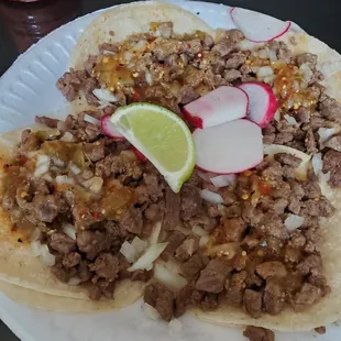 a plate of tacos with meat and vegetables