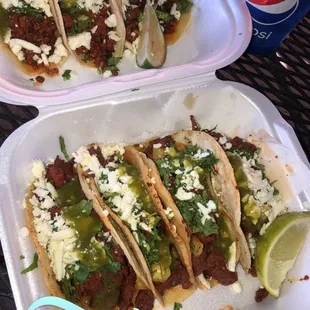 two plates of tacos and a can of soda
