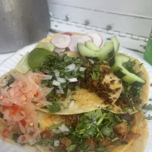 Carne asada and pastor tacos with habanero pickled onions