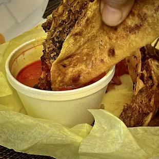 QuesaBirria with consomme-based dipping sauce (or broth).