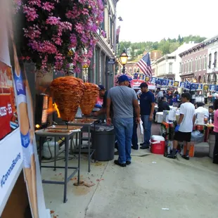 a crowd of people standing around a food stand