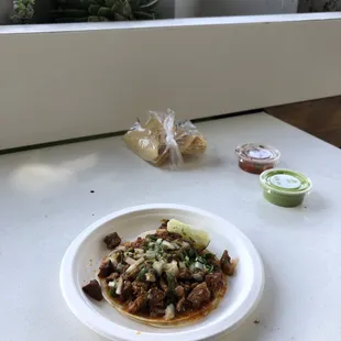 Taco Al Pastor with side sauces and chips. $3