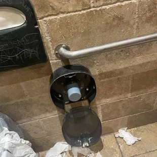 Trash on the floor . NO toilet paper