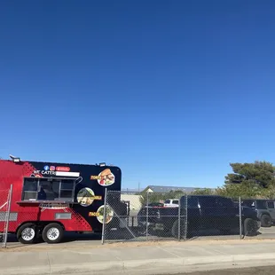 a taco truck behind a chain link fence