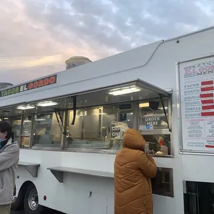 a woman ordering food from a food truck