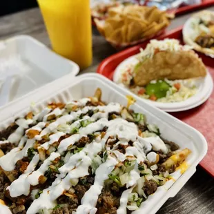 a tray of tacos and a glass of orange juice