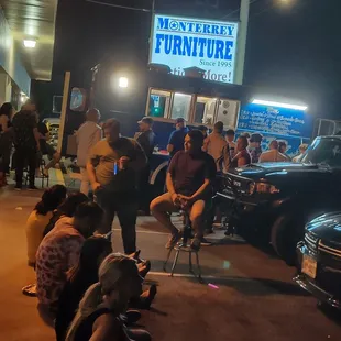 a group of people sitting outside of a restaurant
