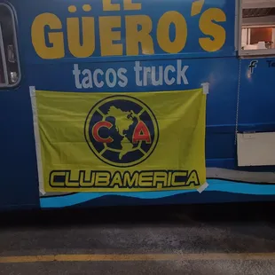a taco truck with a banner on the side