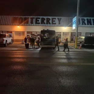 a group of people walking in front of a store