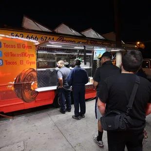 a group of people standing in front of a food truck