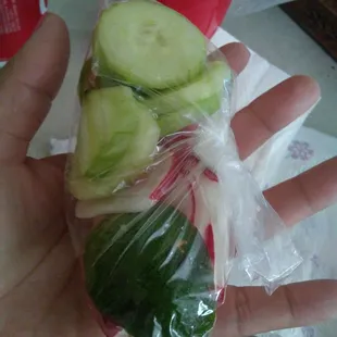 The baggie with the radish and cucumbers
