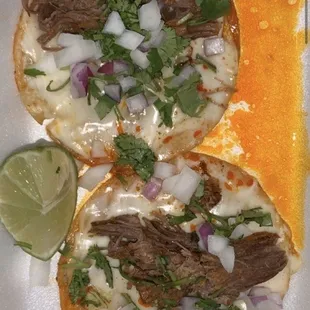 two beef tacos with onions and cilantro sauce