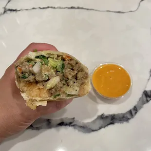 Inside of a Carne Asada Burrito with their own orange sauce.