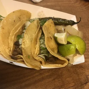 three tacoss in a paper container