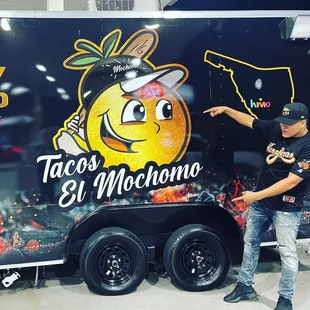 a man pointing to a taco truck