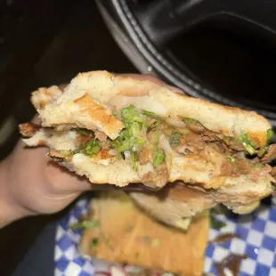 a hand holding a sandwich