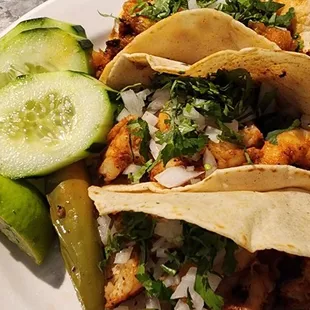 a plate of tacos and a cucumber