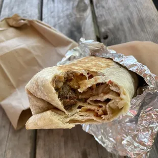 a hand holding a burrito