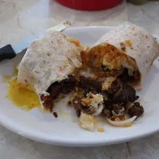 Torpedo burrito contents - steak, grilled cheese, grilled onions, egg over easy, and rice.