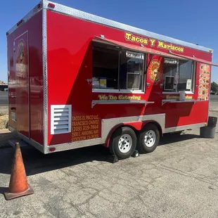 Look for the red food truck by the blue convenience store