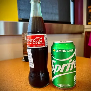 a bottle of soda and a can of soda